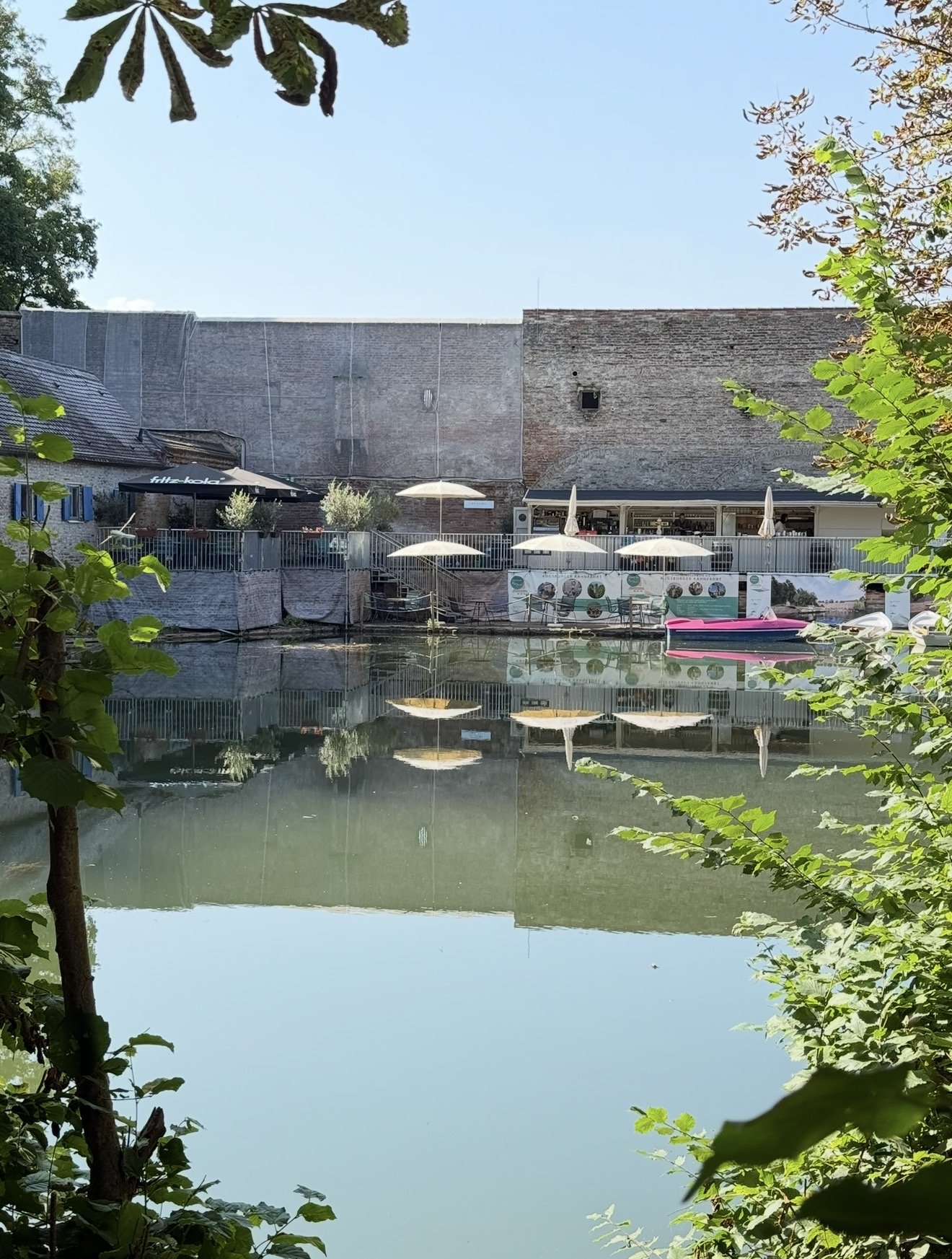 Augsburger Kahnfahrt mit Café am historischen Wall im Spiegelbild des Wassers